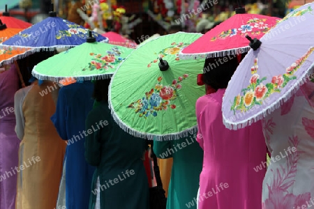 Menschen mit Papierschirmen an der Festparade beim Bun Bang Fai oder Rocket Festival in Yasothon im Isan im Nordosten von Thailand. 