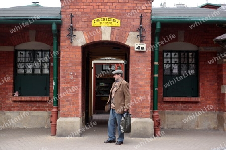 Ein Mann vor der alten Markthalle im Stadtteil Kazimierz in der Altstadt von Krakau im sueden von Polen. 