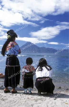 People at the coast of Lake Atitlan mit the Volcanos of Toliman and San Pedro in the back at the Town of Panajachel in Guatemala in central America.   