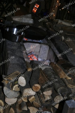 gluehende Feuerstelle mit Holzscheite in der Nacht