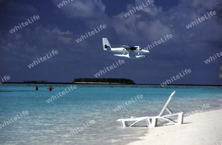 
Ein Wasserflugzeug in der Luft ueber den Inseln der Malediven im Indischen Ozean.  