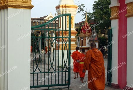 Moenche auf ihrem Rundgang am fruehem Morgen vor dem Tempel Wat Sainyaphum in der Stadt Savannahet in zentral Laos an der Grenze zu Thailand in Suedostasien.