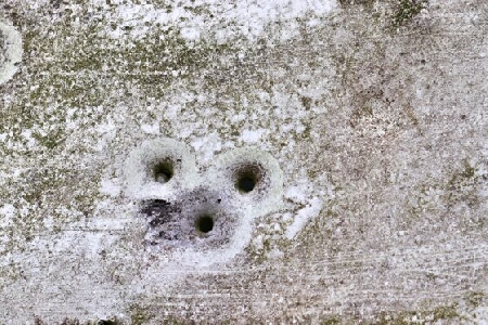 Detailed close up of bullet holes from gun shots in a german traffic sign