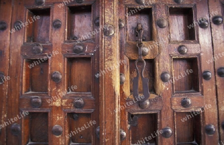 Eine alte Holztuer inmitten der Altstadt Stone Town der Hauptstadt Zanzibar Town auf der Insel Zanzibar welche zu Tansania gehoert.     