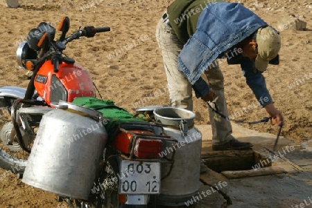 Mann holt Wasser mit Motorrad