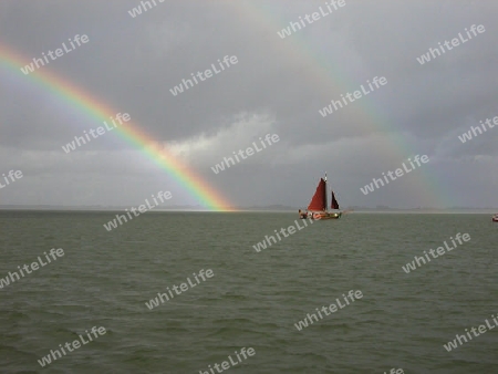 Segelboot und doppelter Regenbogen
