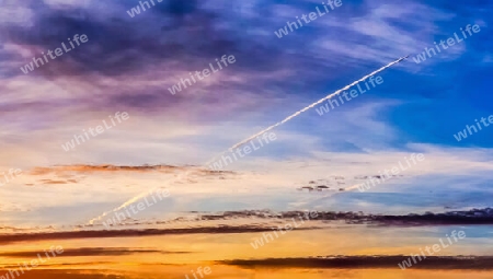 Beautiful high resolution panorama of orange and red sunset clouds in the evening sky.