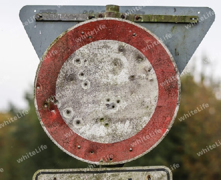 Detailed close up of bullet holes from gun shots in a german traffic sign