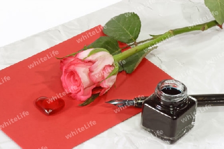 Rose mit Papier und Schreibutensilien