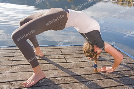 Junge Frau beim Yoga am See 