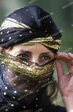 Eine Tunesische Frau in traditionellem Kopftuch  in Monastir am Mittelmeer im Nordosten von Tunesien in Nordafrika.