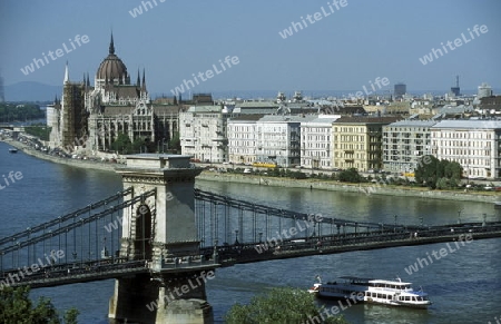 Die Kettenbruecke ueber der Donau und das Parlament in der Hauptstadt von Ungarn in Osteuropa..