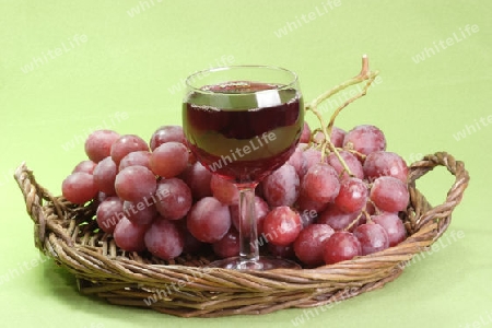 Rotwein und Weintrauben auf gr?nem Hintergrund