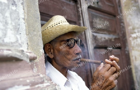 a signor with a cigar in the city of Santiago de Cuba on Cuba in the caribbean sea.